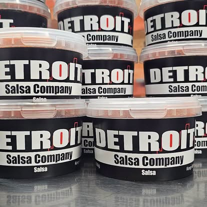 Stacked Detroit Salsa Company tubs with the black label, white DETROIT and the white Salsa Company bar.